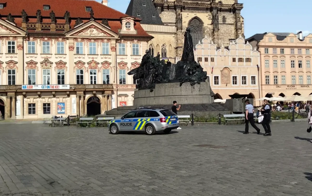 Тынский храм и памятник Яну Гусу на Староместской площади в Праге с полицейской машиной на переднем плане