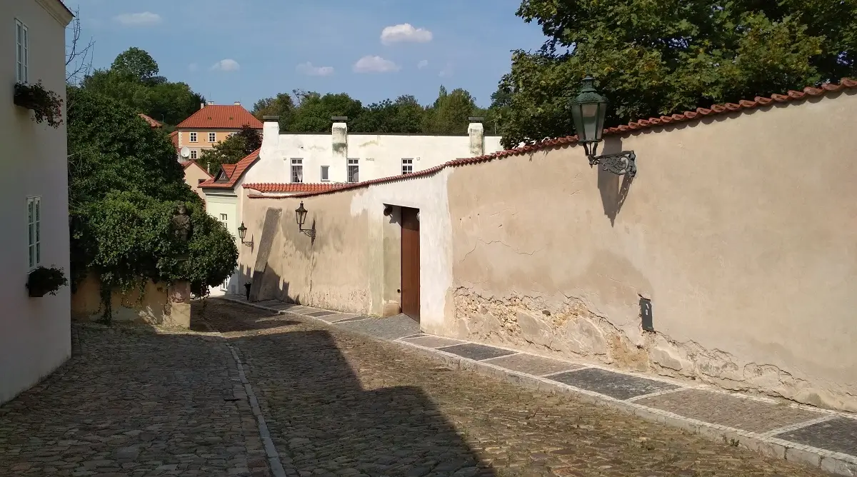 мощеная булыжником улица в историческом районе в Праге с видом на старинные стены и дома