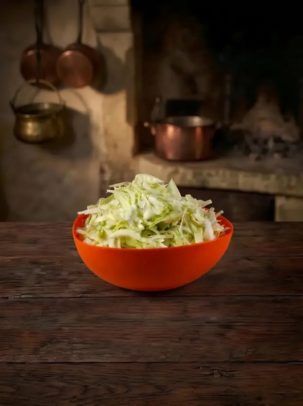 Чешская кухня. Тушеная капуста свежая нашинкованная капуста в оранжевой миске для приготовления тушеной капусты по-чешски